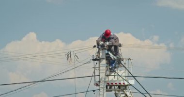 a team of male electricians perform work on the replacement of the cable.
