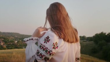 happy young woman enjoying the sunset, wearing traditional ukrainian clothes. lifestyle in Ukraine