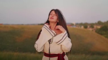 happy young woman enjoying the sunset, wearing traditional ukrainian clothes. lifestyle in Ukraine