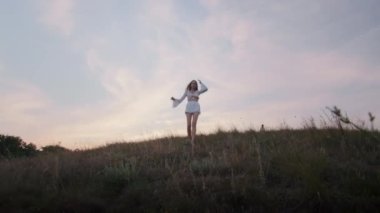 happy young woman enjoying the sunset, wearing traditional ukrainian clothes. lifestyle in Ukraine