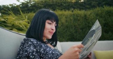 a european woman enjoys time in a restaurant, she chooses delicious food from the menu. she is filled with joy.