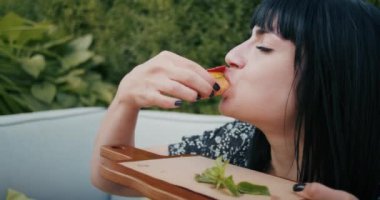 a happy woman enjoys food in a restaurant or cafe, she eats delicious food and is filled with joy.