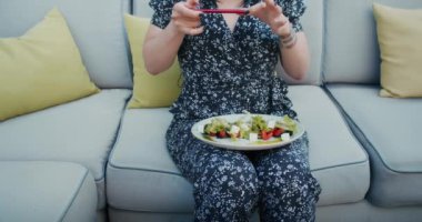 a happy woman photographs beautiful food in a restaurant, she is filled with joy