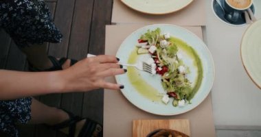 a cheerful woman enjoys food in a restaurant, she eats it with pleasure and fills her with joy
