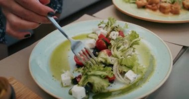a cheerful woman enjoys food in a restaurant, she eats it with pleasure and fills her with joy