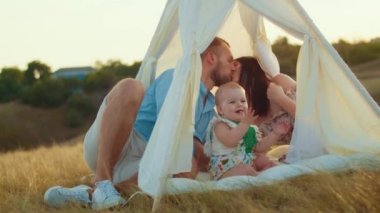 Childs 'ın yaşam tarzı. Sonbahar tarlasında mutlu yıllar. Gün batımında küçük çocuk, çadırda pastayla. Fotoğrafçı doğum günü fotoğrafı çekiyor. Aile ve bebek sevinci