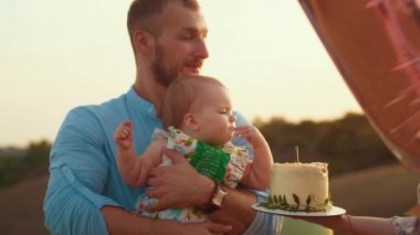 Childs 'ın yaşam tarzı. Sonbahar tarlasında mutlu yıllar. Gün batımında küçük çocuk, çadırda pastayla. Fotoğrafçı doğum günü fotoğrafı çekiyor. Aile ve bebek sevinci