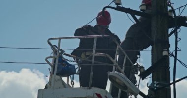 a team of male electricians perform work on the replacement of the cable.