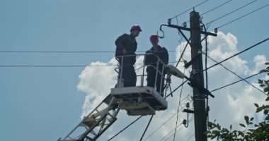 a team of male electricians perform work on the replacement of the cable.