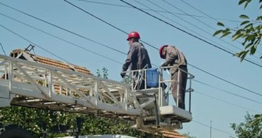 a team of male electricians perform work on the replacement of the cable.