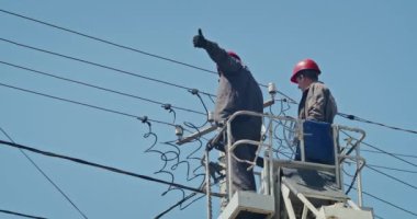a team of male electricians perform work on the replacement of the cable.