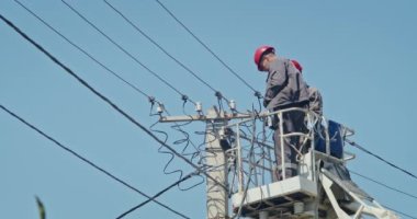 a team of male electricians perform work on the replacement of the cable.