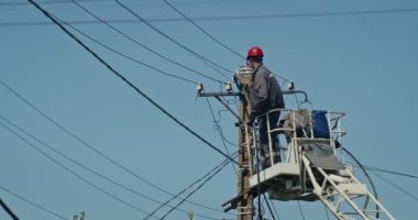 a team of male electricians perform work on the replacement of the cable.
