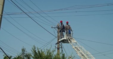 a team of male electricians perform work on the replacement of the cable.