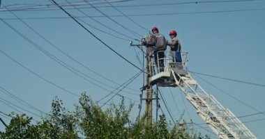 a team of male electricians perform work on the replacement of the cable.