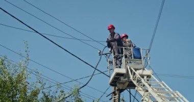 a team of male electricians perform work on the replacement of the cable.