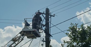 a team of male electricians perform work on the replacement of the cable.
