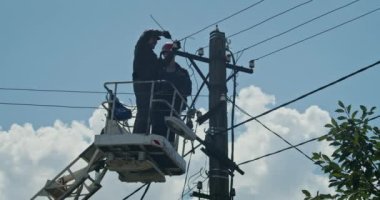 a team of male electricians perform work on the replacement of the cable.