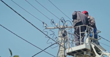 a team of male electricians perform work on the replacement of the cable.