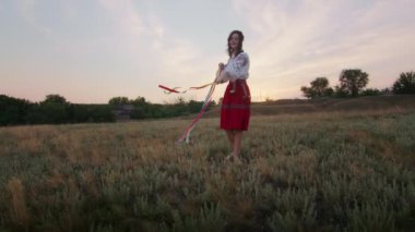 happy young woman enjoying the sunset, wearing traditional ukrainian clothes. lifestyle in Ukraine