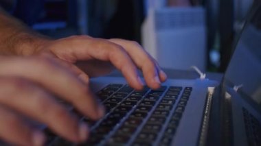 Yakın plan, erkek bir video editörünün elleri stüdyodaki bir dizüstü bilgisayarda işlem görüyor.