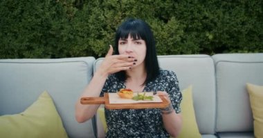 a happy woman enjoys food in a restaurant or cafe, she eats delicious food and is filled with joy.