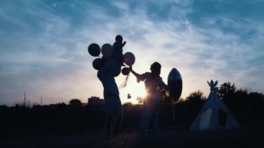 Childs 'ın yaşam tarzı. Sonbahar tarlasında mutlu yıllar. Gün batımında küçük çocuk, çadırda pastayla. Fotoğrafçı doğum günü fotoğrafı çekiyor. Aile ve bebek sevinci