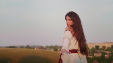 happy young woman enjoying the sunset, wearing traditional ukrainian clothes. lifestyle in Ukraine