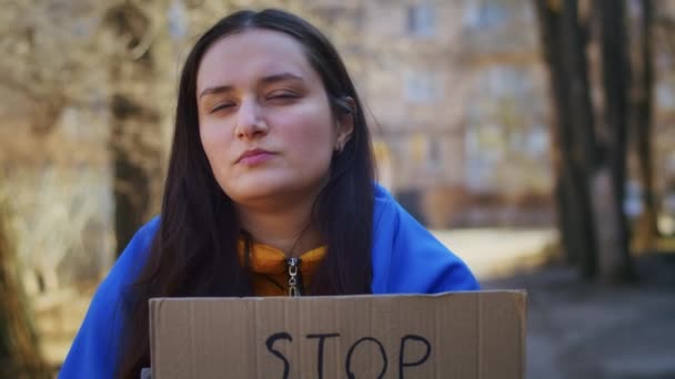 우크라이나 국기와 간판을 우크라이나 여성의 초상화 소녀는 전쟁에서 남편을 기다리고 — 비디오