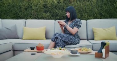 a happy woman photographs beautiful food in a restaurant, she is filled with joy