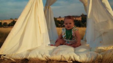 Childs 'ın yaşam tarzı. Sonbahar tarlasında mutlu yıllar. Gün batımında küçük çocuk, çadırda pastayla. Fotoğrafçı doğum günü fotoğrafı çekiyor. Aile ve bebek sevinci