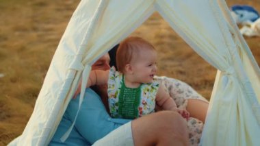 Childs 'ın yaşam tarzı. Sonbahar tarlasında mutlu yıllar. Gün batımında küçük çocuk, çadırda pastayla. Fotoğrafçı doğum günü fotoğrafı çekiyor. Aile ve bebek sevinci