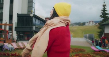 Dağlarda genç bir kadın gezgin kalın giysiler giyer. Sonbahar soğuk havası. Z kuşağı yolculuğu.