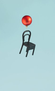 Kırmızı takı ve parlak mavi arka planda sandalye ile Noel dekorasyonu yaratıcı konsepti. Kış ve Yeni Yıl gerçeküstü fikri, minimum dikey düzenleme.