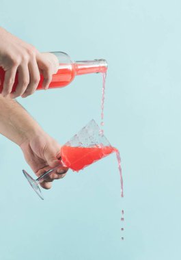 Noel ve Yeni Yıl kutlaması fikri erkeklerin pembe bir içki koyduğu bir fikirdi. Parlak mavi arka plan, minimum dikey düzenleme. Kış mevsimi tatili.