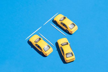 Canlı mavi arka planda sarı arabalı yaratıcı araba ve ulaşım fikri. Grafiksel trafik ve park fikri, en az görsel kompozisyon.