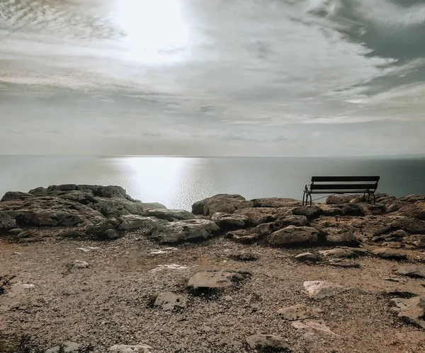 Nyári napsütéses táj. Cavo Greco, Ciprus, Földközi-tenger partja. Egy üres pad egy sziklán.. — Stock Fotó