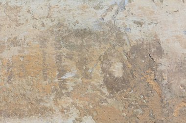 Ayrıntılı dokusu olan eski yıpranmış bir duvar. Bej arkaplan dokusu. Hasarlı beton kaplı bir yüzey..