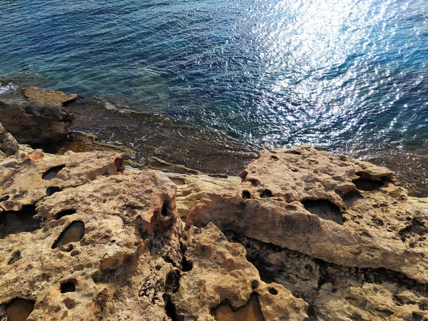 Rocky shore with clear blue water. Seashore with large weathered boulders. Mediterranean Sea coast, Cyprus. — Stock Photo, Image