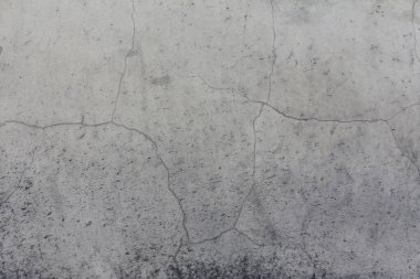 Eski beton bir duvar, çok güzel bir kumaşı var. Çatlaklar ve sıçramalarla yıpranmış gri bir arka plan..