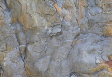 Büyük uçurum yakın, gri kırmızı renk paletli büyük kaya. Doğal taş dokusu. Soyut organik arka plan. Tasarımlarınıza kolayca derinlik ve organik doku ekleyin.