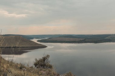 Sakin, pürüzsüz bir su manzarası. Dinyester nehri, Ukrayna 'daki Bakota Körfezi manzarası. Büyük bir nehrin kıyısında. Durgun bej renklerde yaz manzarası.