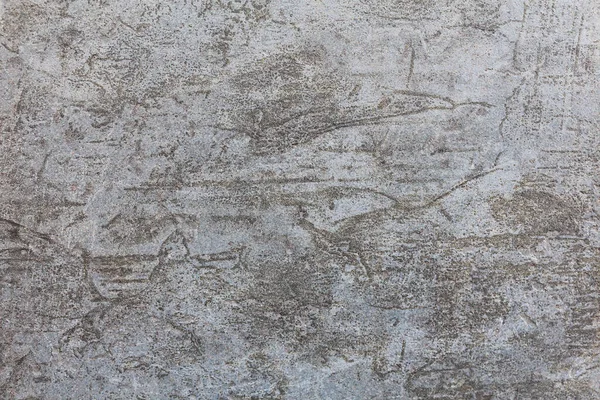 Güzel grunge desenli eski bir beton duvar. Çatlak ve çiziklerle kaplı gri yıpranmış bir arka plan. Şehir fotoğrafı çok az. Tasarımlarınıza kolayca derinlik ve organik doku ekleyin.