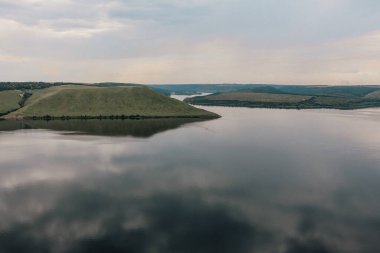 Bakota, Dniester river, Ukraine. Smooth calm water. The banks of a large river, panoramic landscape. High banks, green hills. Summer sunny day in Eastern Europe.