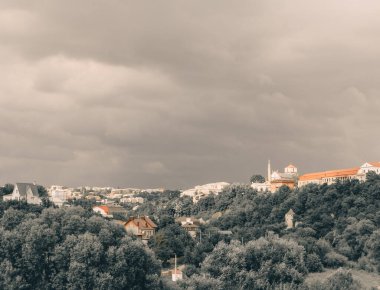Kamianet-Podilskyi, Doğu Avrupa, Ukrayna. Küçük kasaba manzarası. Şehir, kırsal, fırtınalı gökyüzüne karşı küçük evler. Sakin ve sessiz renklerde bir fotoğraf.
