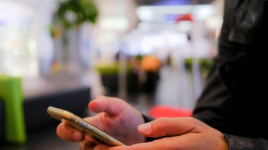 Havaalanında eli telefonlu bir kadın. Sohbet, video görüşmesi, sosyal....