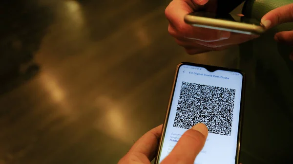 Elinde telefon olan bir kadının elleri kimlik taraması yapar. Yeşil kart. Elektronik. havaalanı konumu