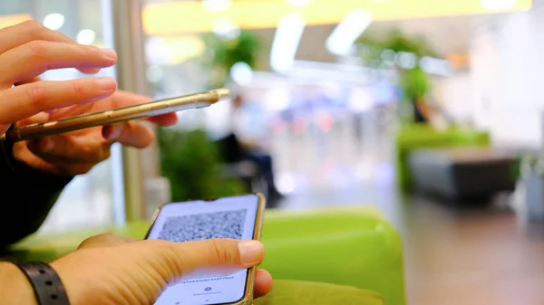 Elinde telefon olan bir kadının elleri kimlik taraması yapar. Yeşil kart. Elektronik. havaalanı konumu