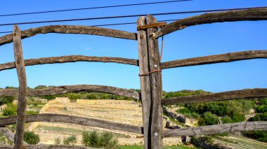 Tipik Minorcan kapısı ahşaptan yapılmış, arkasında da manzara var. Menorca, Balear Adaları, İspanya.