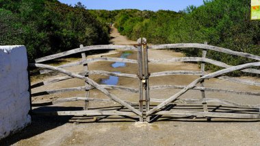 Tipik Minorcan kapısı ahşaptan yapılmış, arkasında da manzara var. Menorca, Balear Adaları, İspanya.